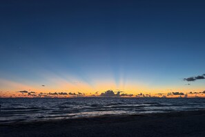 A beach at sunset with waves and a clear sky. - Stay steps from the sand in this charming single-family home.  Enjoy exclusive beach access at Sunburst Inn, just 2 min walk!  Cozy comfort for up to 4, and an unbeatable location on the Gulf. Perfect for a romantic escape or a lively getaway. (Indian Shores)