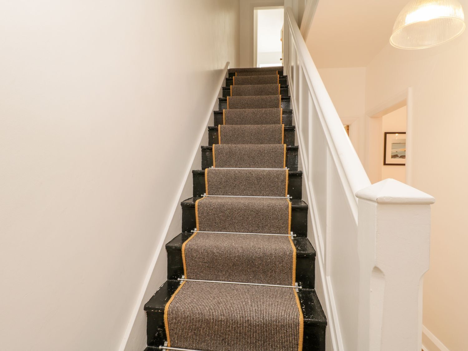 A staircase with carpeted steps and a white handrail.
