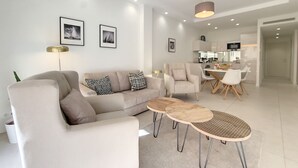 Uma sala de estar moderna com sofá, mesa de centro e área de jantar.