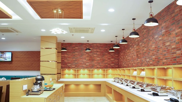 A modern restaurant with a brick wall, wooden counter, and pendant lighting. - Comfort Inn Udaipur (Udaipur)