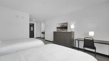 A hotel room with two beds, a desk with a chair, a dresser, and a painting on the wall.