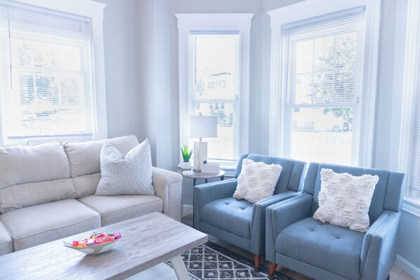 A living room with a sofa, two armchairs, a coffee table, and a lamp. - Modern & Spacious 4 Bedroom Single Family Home (Worcester)