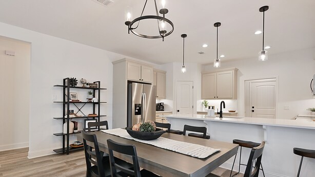 A modern kitchen with white cabinets, a central island, and pendant lighting. - Newly built home minutes from Texas A&M campus (College Station)