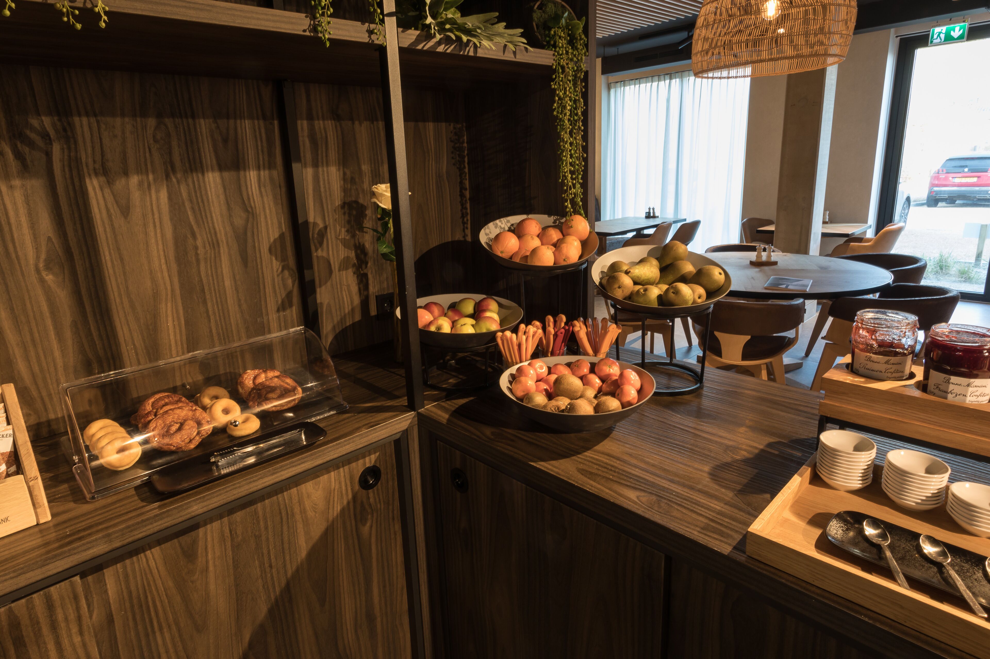 A buffet setup with various fruits, vegetables, and pastries.