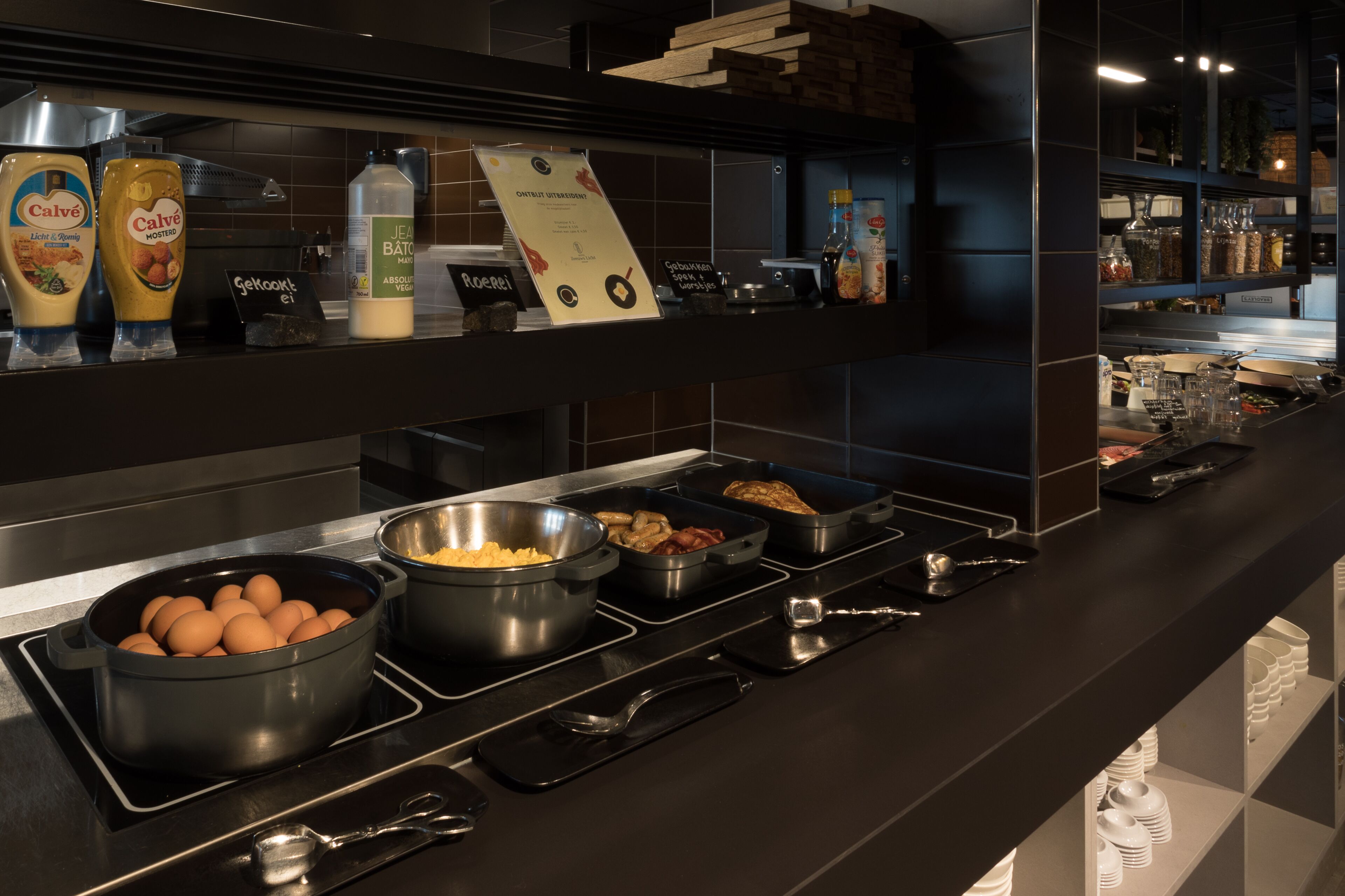 A buffet setup with various food items and condiments.