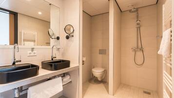 Une salle de bain moderne avec un double vasque, des toilettes et une douche.