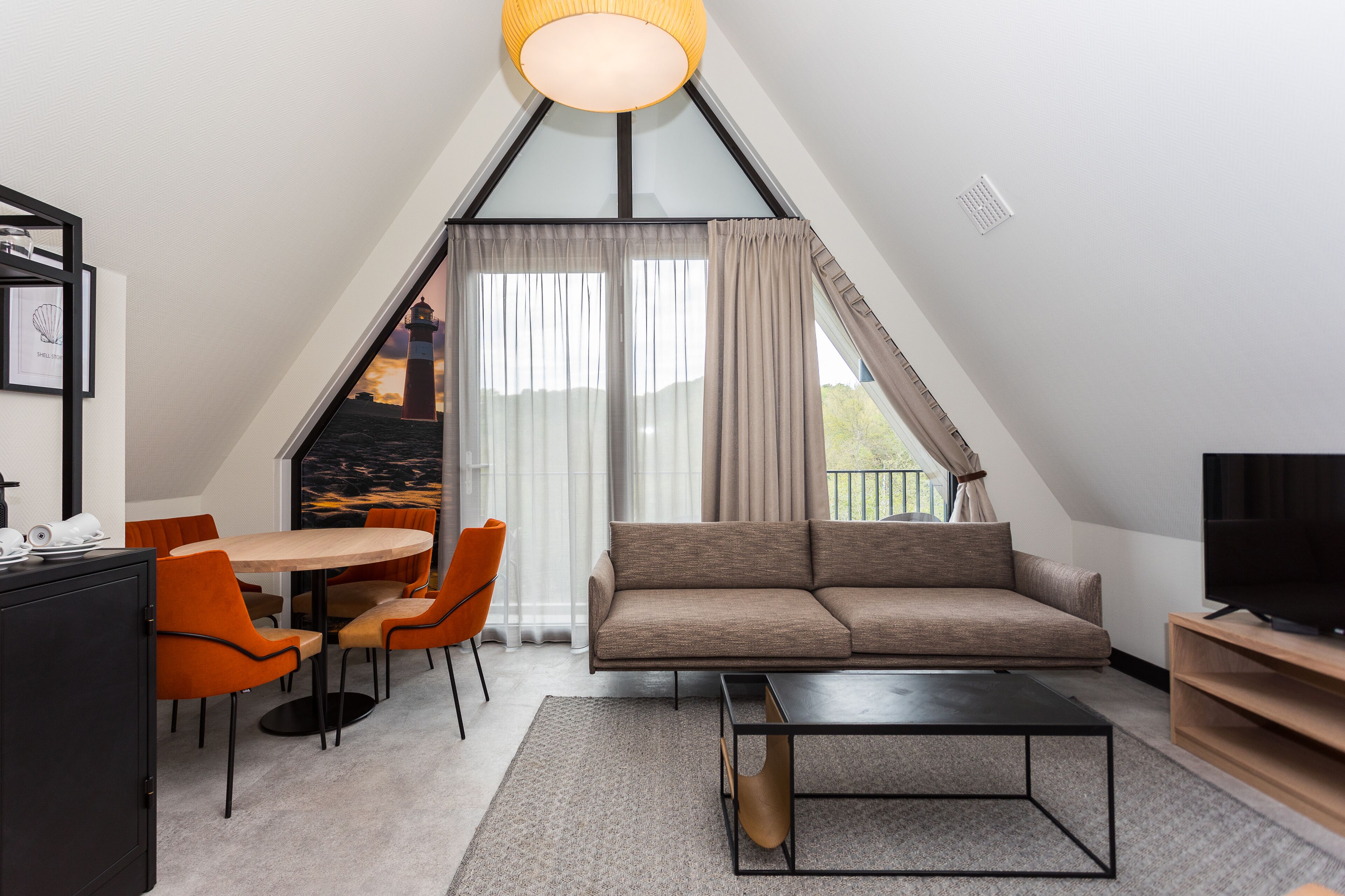 Une chambre moderne de style loft, comprenant un canapé, une table à manger, des chaises et un téléviseur.