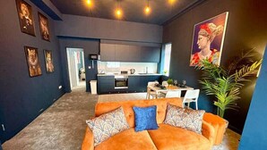 Ein modernes Wohnzimmer mit einer Couch, einem Essbereich und einer Küche.