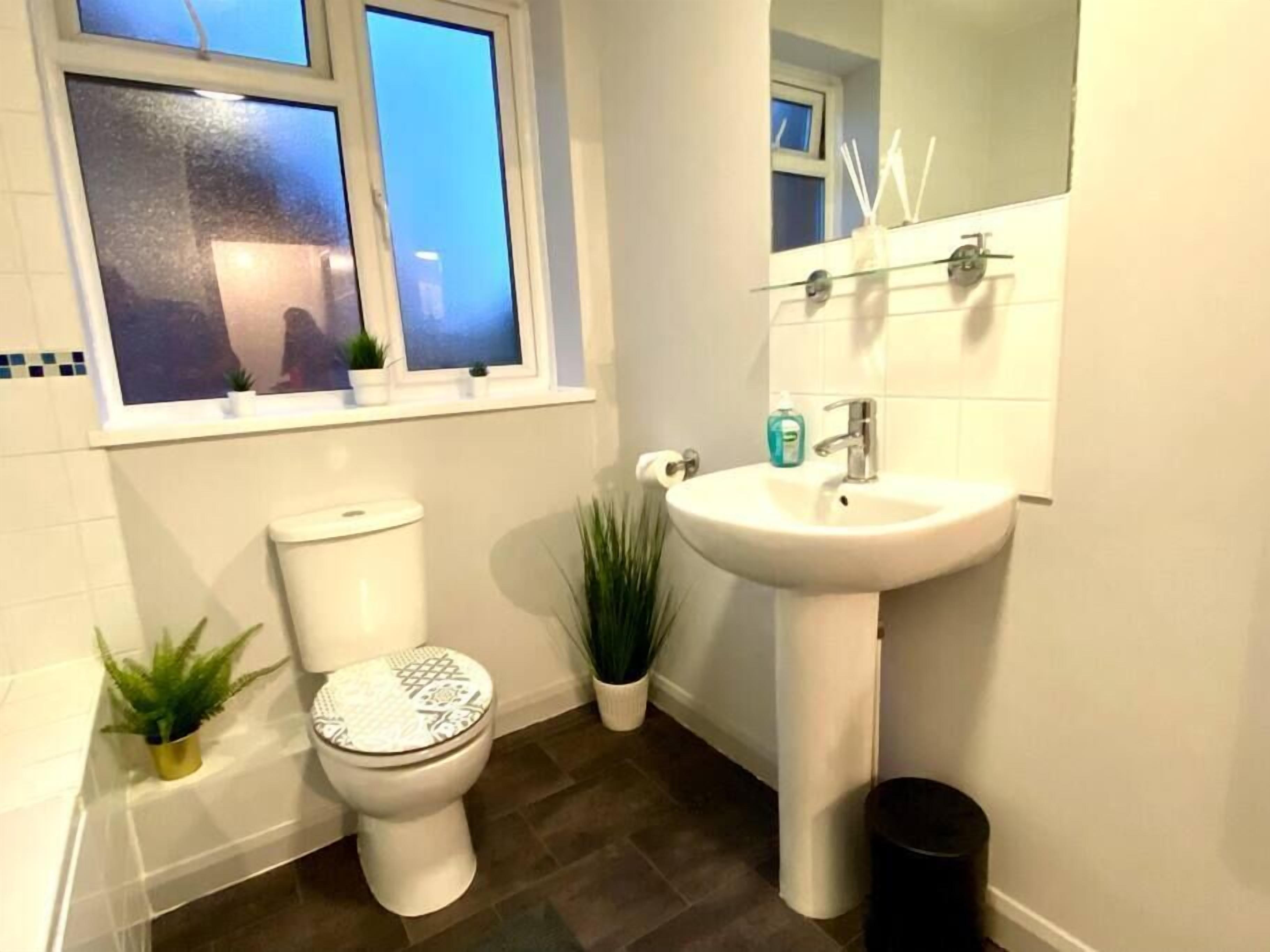 Un baño con inodoro, lavamanos y ventana.