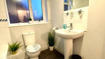 Un baño con inodoro, lavamanos y ventana.