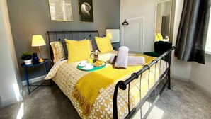 A neatly arranged bedroom with a bed, bedside tables, a mirror, and a window with curtains. - Trendy Apartment - 5 minute walk to the beach! (Bournemouth)