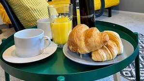 A breakfast setup with a coffee pot, a glass of orange juice, a cup, and croissants on a tray. - Trendy Apartment - 5 minute walk to the beach! (Bournemouth)