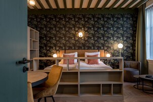 Un dormitorio con una cama litera, un escritorio, una silla y una mesita.