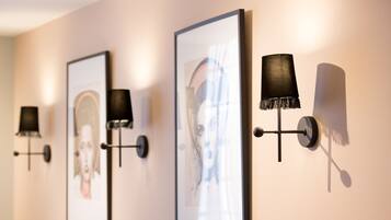 Wall-mounted lamps and framed artwork in a hallway.