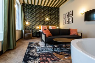 Una sala de estar moderna con un sofá, una mesa de centro redonda y una bañera blanca grande.
