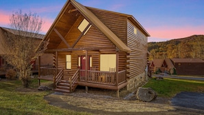 A log cabin with a porch, a staircase, and a view of the surrounding landscape. - Super Views, Flat roads, Hot Tub (Gatlinburg)