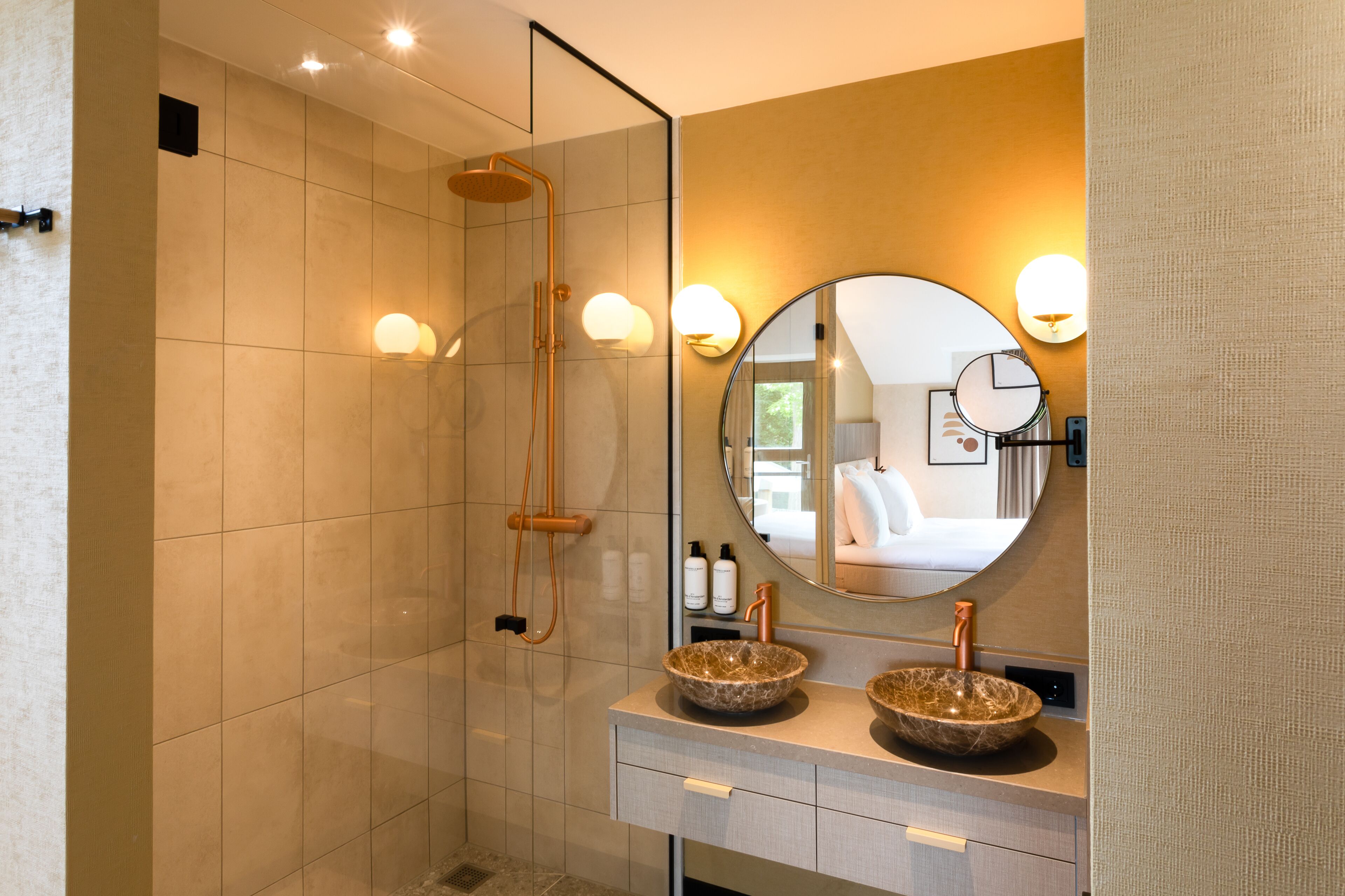 Een moderne badkamer met twee wasbakken, een grote spiegel en een douche met glazen wanden.