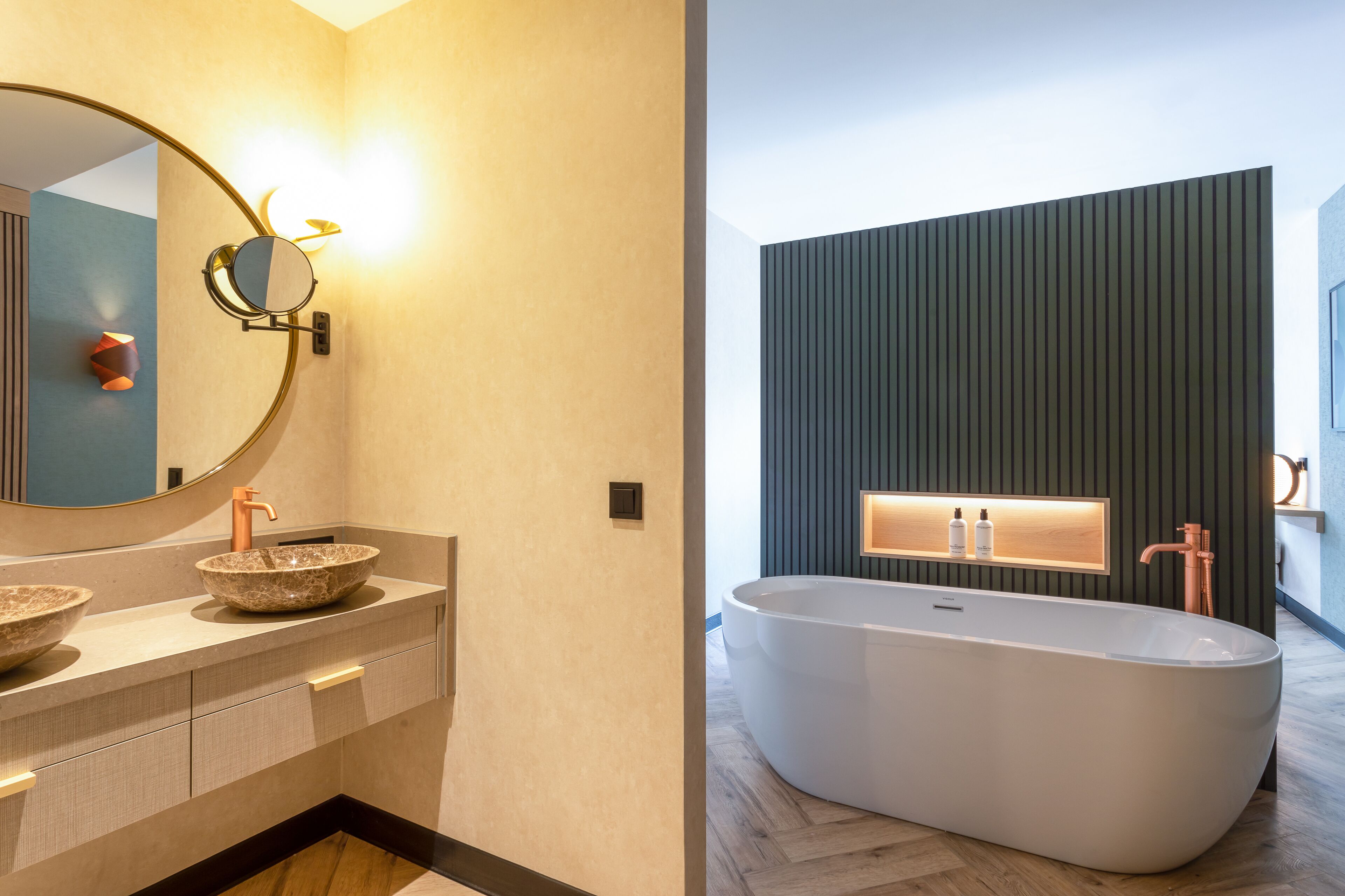 Un baño moderno con una bañera independiente, un espejo redondo y un lavabo sobre encimera.
