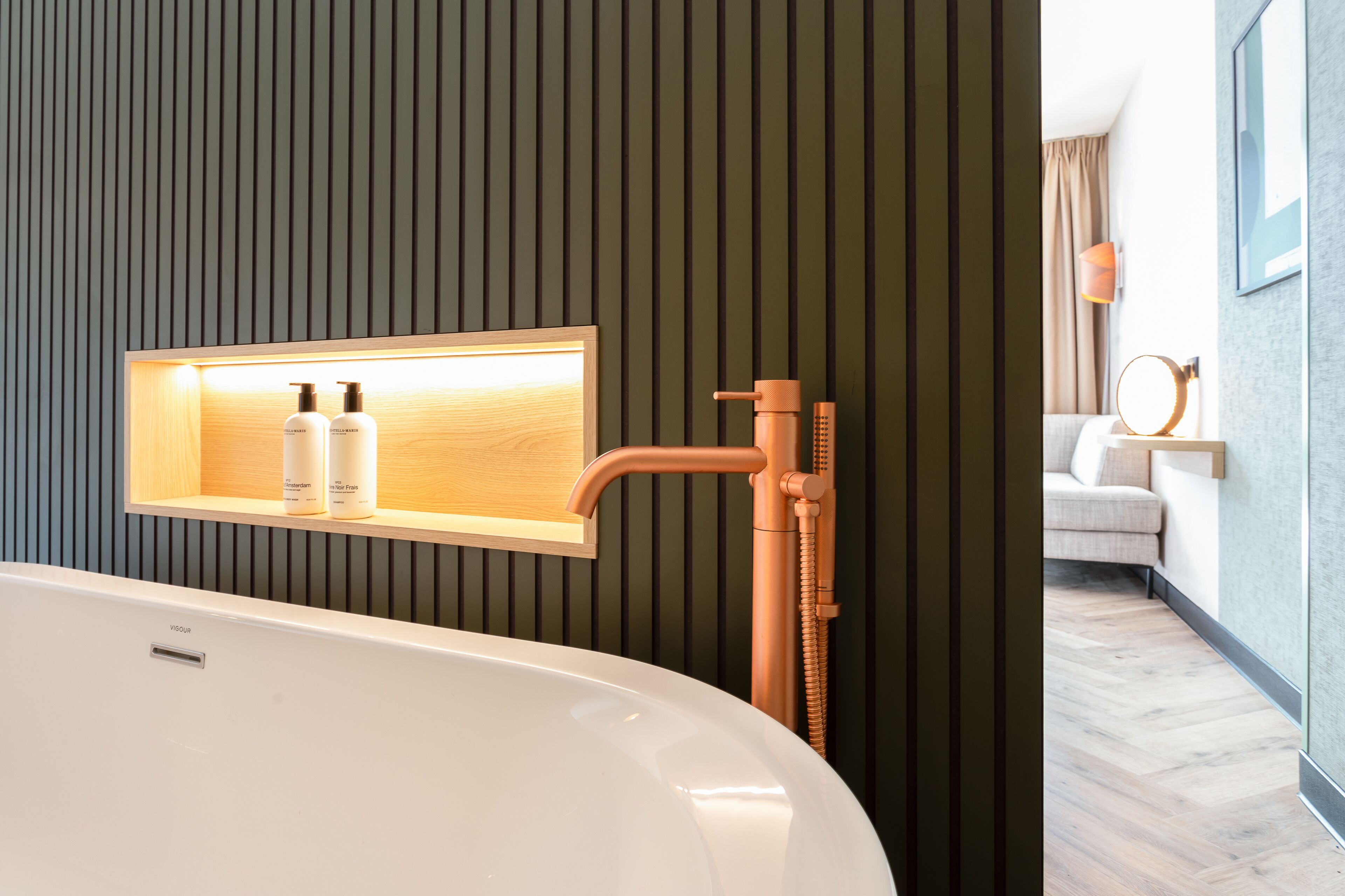 A modern bathroom with a freestanding bathtub, a wall-mounted vanity with a mirror, and a towel rack.