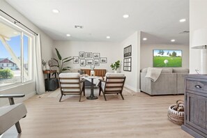 Relax in this stylish living room with a dining area, comfortable sofa, and large flat-screen TV.