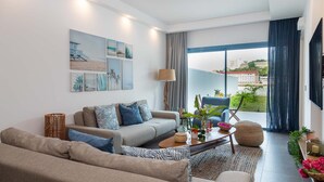 A modern living room with a sofa, armchairs, a coffee table, and artwork on the wall. - The Lead Hotel (Freetown)