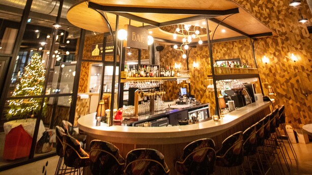 A multi-level bar area with a high ceiling, glass walls, and a Christmas tree. - Hotelboot Koningin Emma Kloeg Collection (Vlissingen)