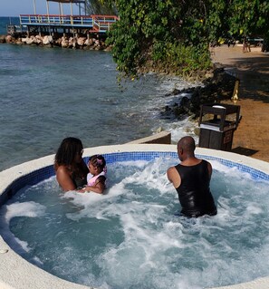 Een hottub met uitzicht op de zee en een houten terras.