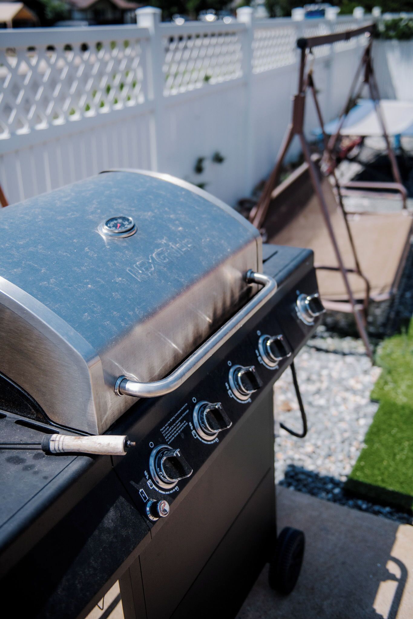 A portable grill with four burners and a control panel.