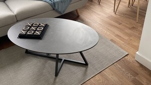 A modern living room with a grey sofa, a round coffee table with wooden letter blocks, and a dining area with two grey chairs and a glass table. - Poulorio 13 proche gare ★ T2 ★ Dernier Etage * By Locly * (Lorient)