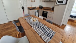 Une cuisine moderne avec une table en bois, des chaises et un chemin de table à rayures.
