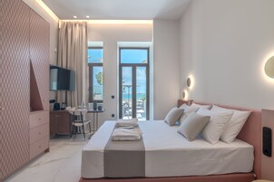 Una habitación de hotel moderna con una cama grande, un escritorio y una televisión.