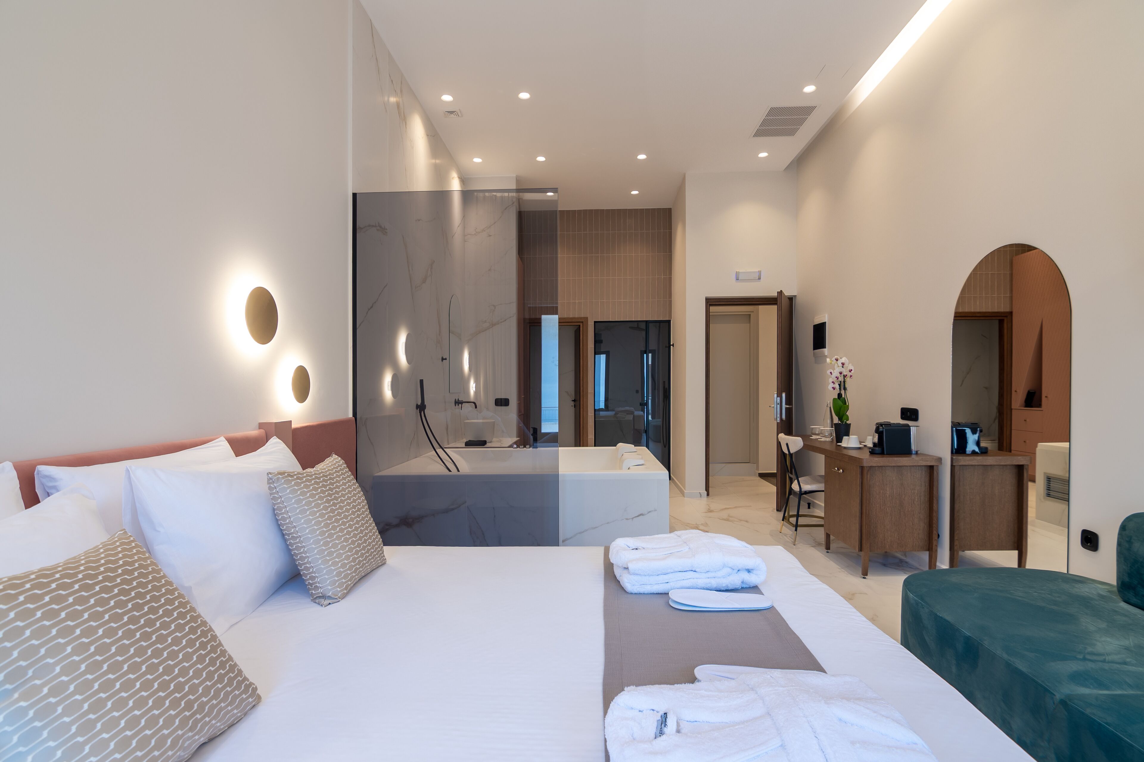 Una habitación de hotel moderna con una cama grande, un escritorio y un baño.