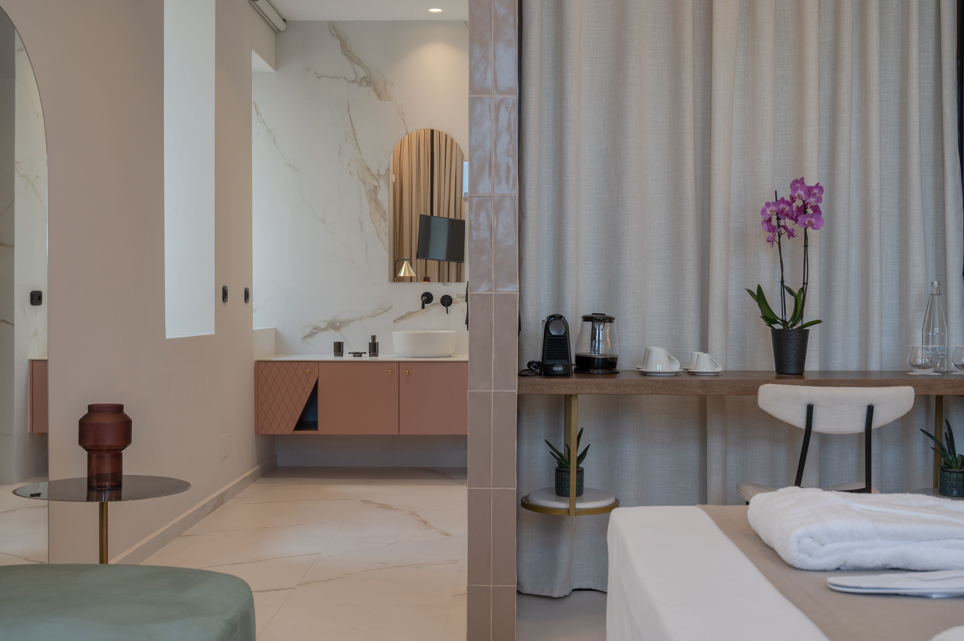 A modern bathroom with a marble vanity, a mirror, a sink, and a shower area.