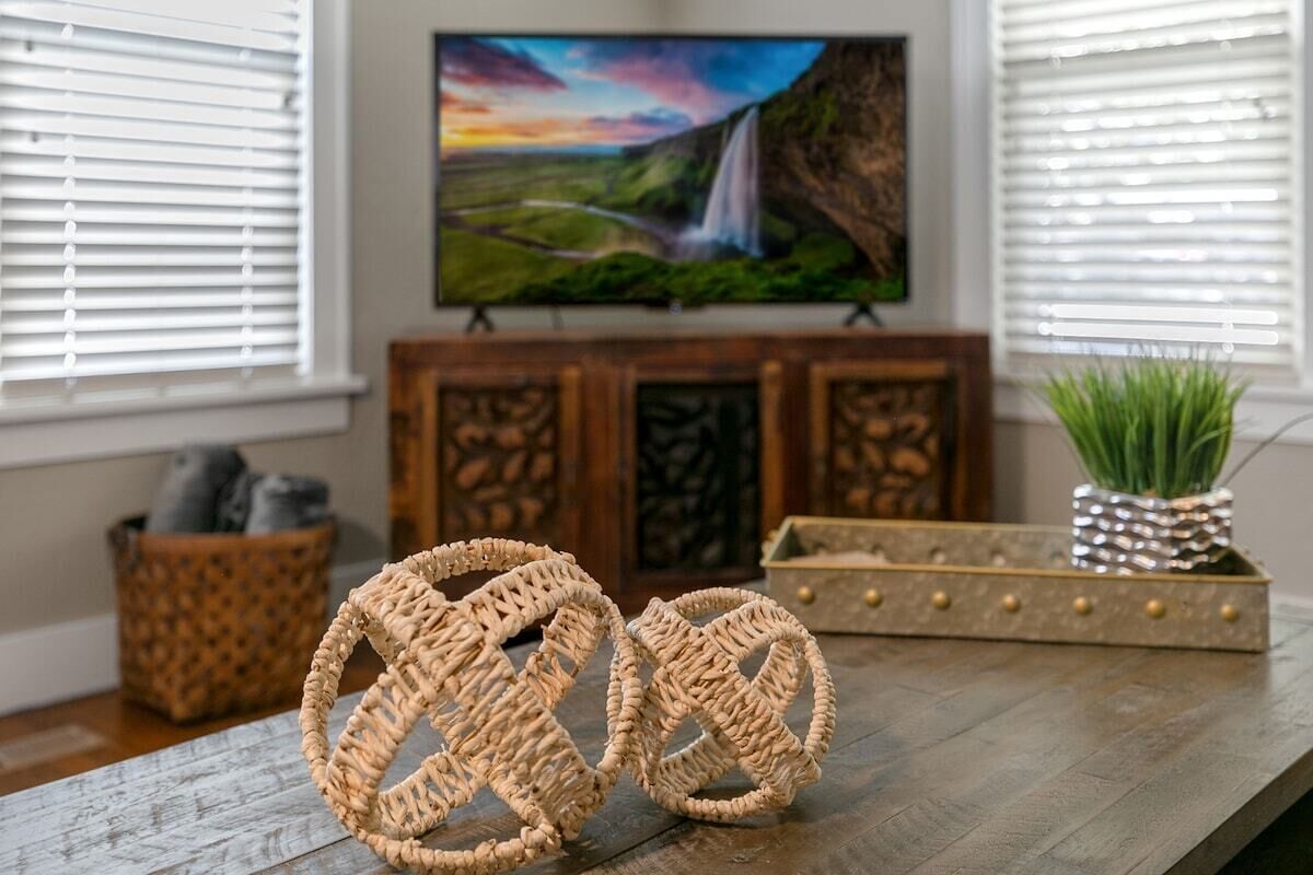 A wooden table with woven baskets and a decorative tray with a plant.