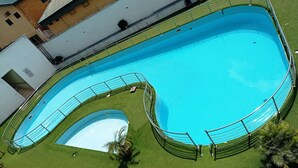 A large, rectangular swimming pool with a surrounding deck and a smaller circular pool. - Golden Royale Hotel (Enugu)