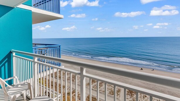 A balcony with white railings overlooking a beach with a clear view of the ocean. - Stunning Views in Atlantica Resort (Myrtle Beach)