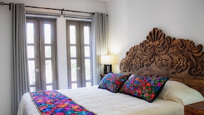 A bedroom with a large bed, floral bedspread, and a wooden headboard. - BELLAS VILLAS VILLA SOL HERMOSA CASA y ACCESIBLE PRECIO (San Miguel de Allende)