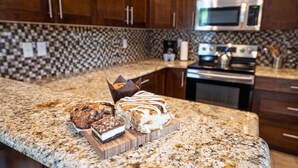 A kitchen with granite countertops, wooden cabinets, a microwave, and an oven. - Aspen Lodge by Revelstoke Vacations (Revelstoke)