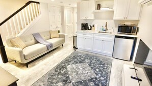 A modern kitchen with white cabinets, a microwave, and a coffee maker.