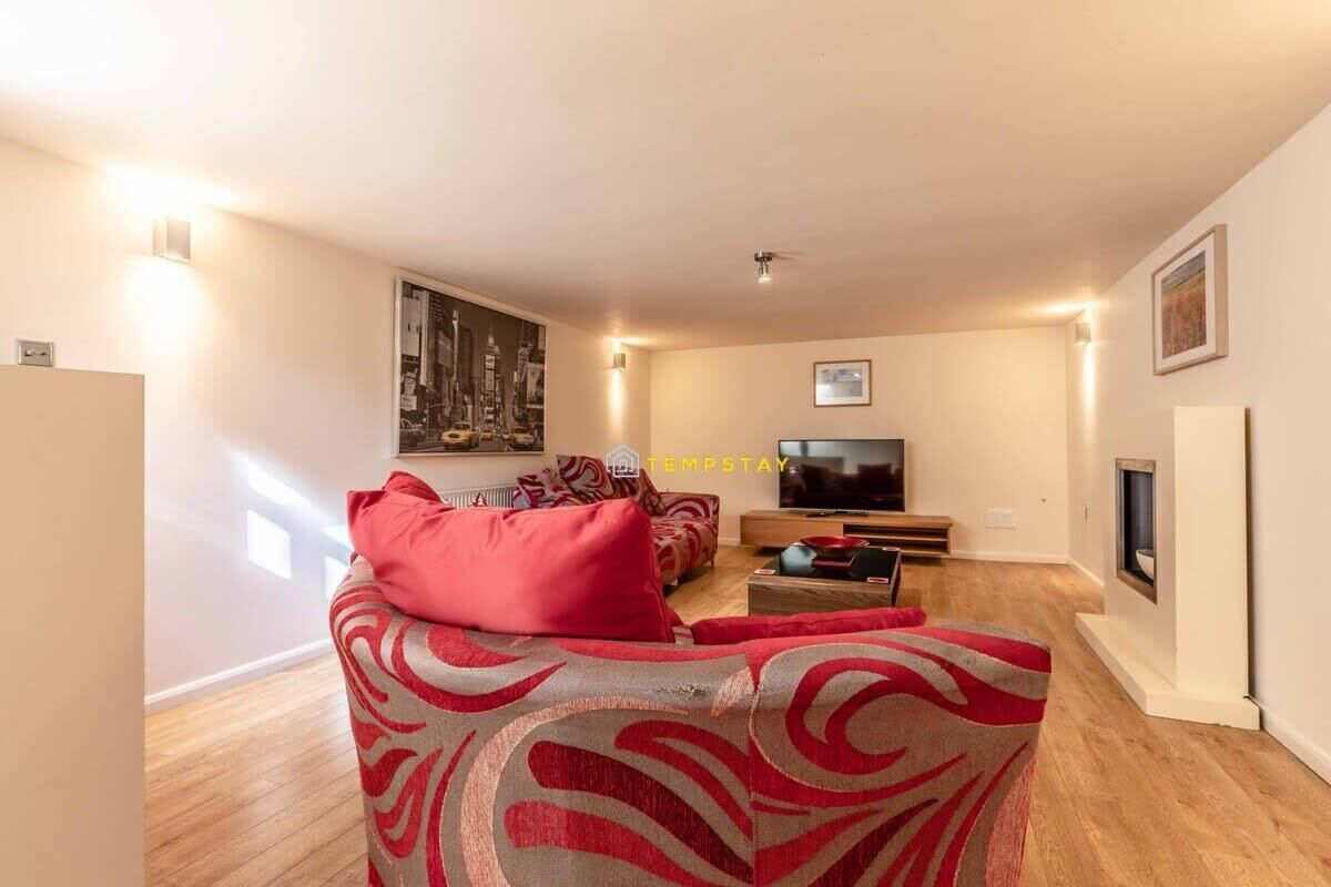 A living room with a sofa, a television, and a fireplace.