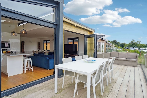 Una casa moderna con cocina integrada, comedor y zona de estar exterior.