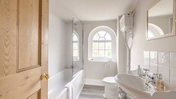 Bathtub, hair dryer, towels, shampoo