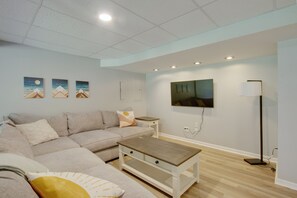 Relax in this stylish living room with a large L-shaped sofa, flat-screen TV, and wooden coffee table.