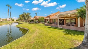 Un quartier résidentiel avec un canal, des maisons dotées de patios et un ciel d’un bleu éclatant.
