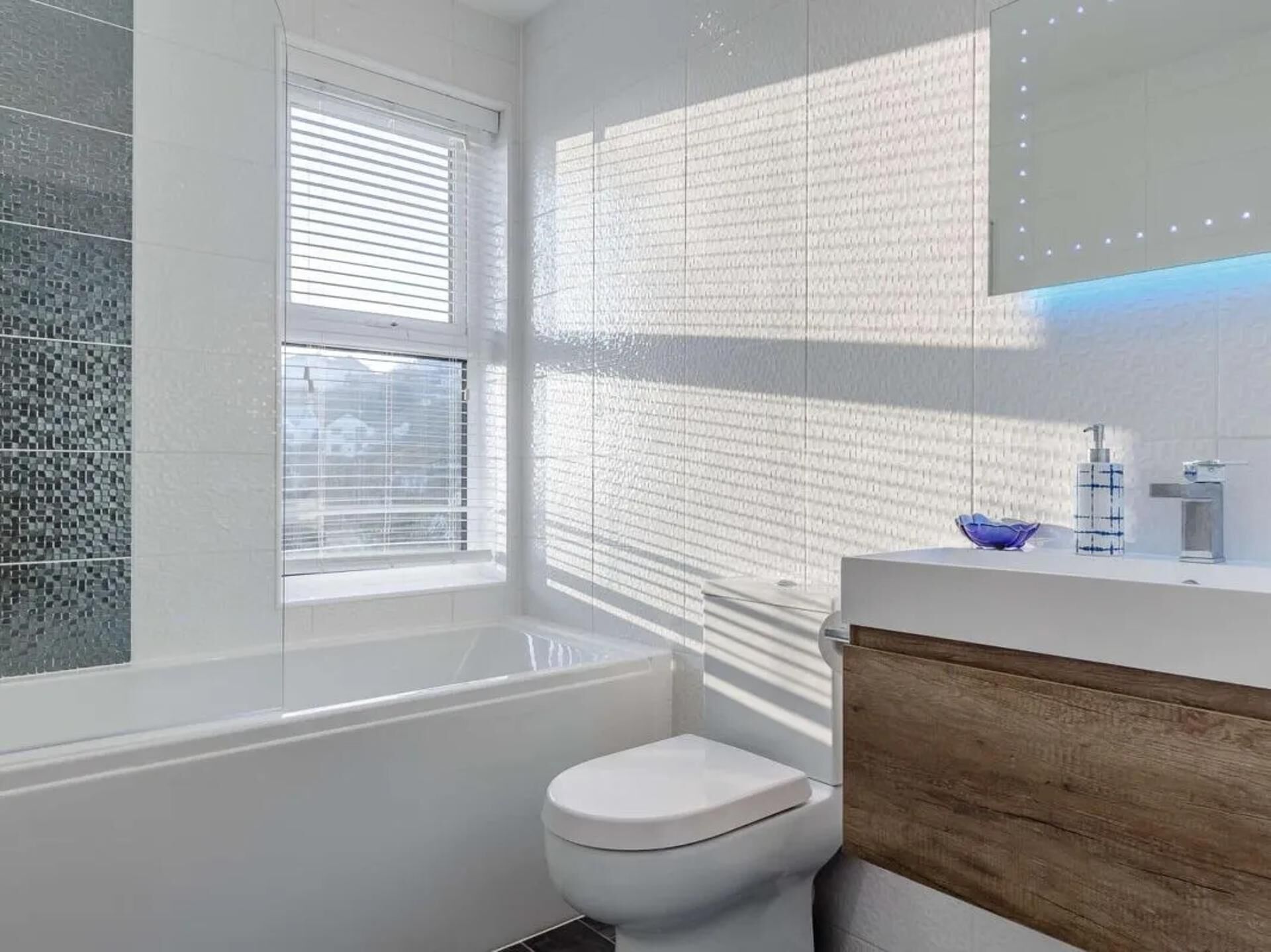 Een moderne badkamer met een badkuip, toilet en wastafel.