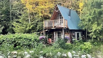 Enjoy the serene forest views from the cabin's spacious balcony with a railing.