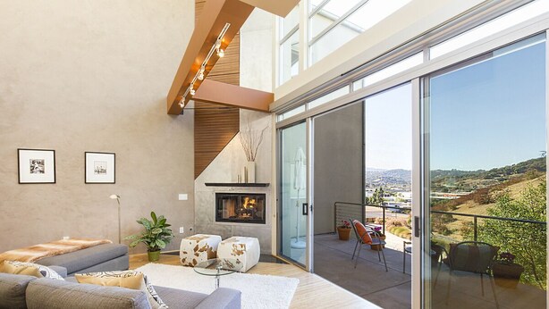 A modern living room with a fireplace, a sofa, and a balcony with a view of the countryside. - Ultra modern loft with 3-floor sunlight, 15 min from GGbridge (San Rafael)