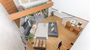 A modern living room with a sofa, coffee table, and a dining area. - Ultra modern loft with 3-floor sunlight, 15 min from GGbridge (San Rafael)