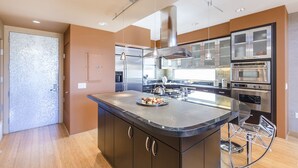 A modern kitchen with a central island, stainless steel appliances, and a bar stool. - Ultra modern loft with 3-floor sunlight, 15 min from GGbridge (San Rafael)