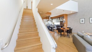 A modern interior with a wooden staircase, a dining area, and a kitchen. - Ultra modern loft with 3-floor sunlight, 15 min from GGbridge (San Rafael)